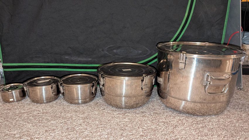 Various sizes of stainless steel containers, arranges smallest on the left to largest on the right.