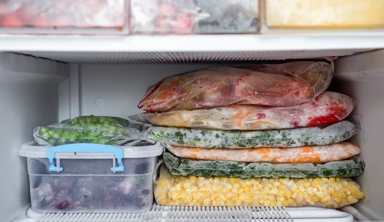 Food that has been bagged and neatly stacked on a freezer shelf