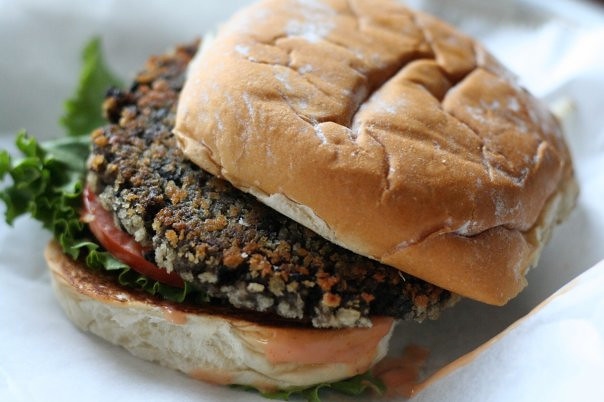 A black bean burger on a bun with lettuce and tomato toppings.