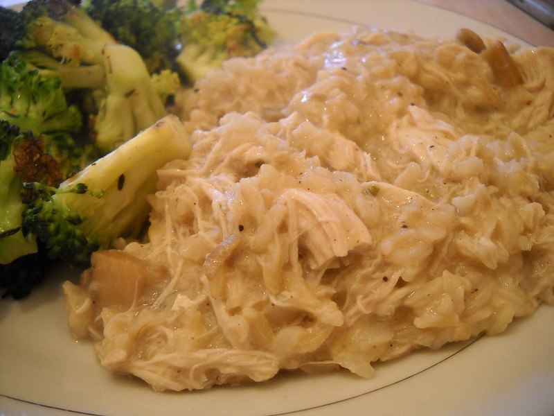 A plate of chicken and rice casserole, with steamed broccoli on the side.