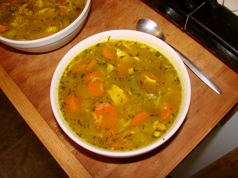 A bowl of chicken soup with root vegetables.