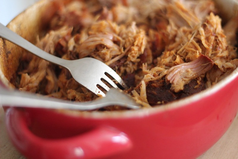 Pulled pork in a baking dish. The pork has been shredded with two forks.