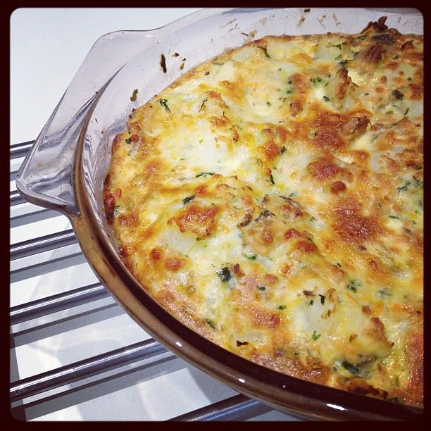 Salmon potato bake in a baking dish, covered in melted cheese.