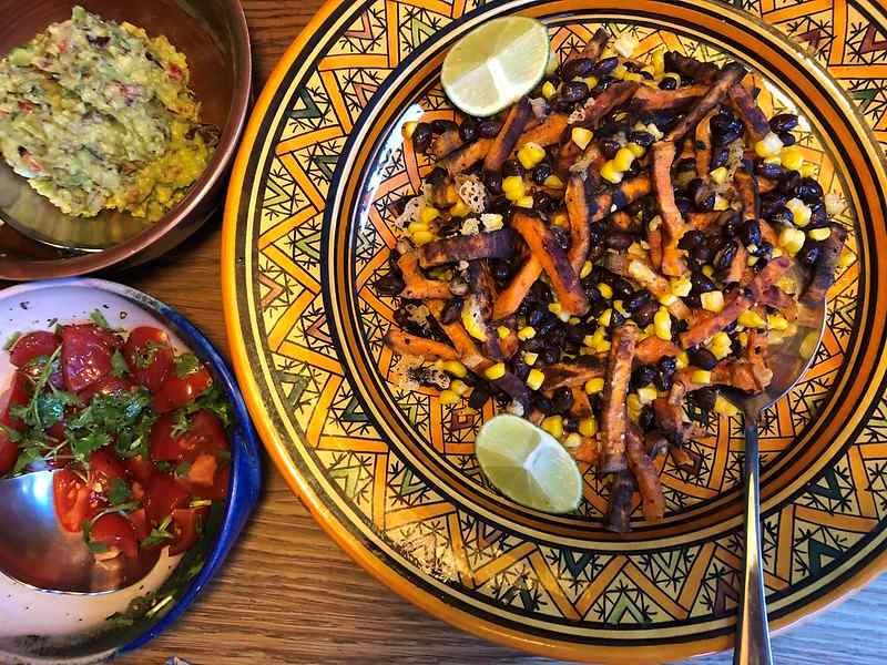 A plate of sweet potato, corn, and black bean salad, with two side dishes.