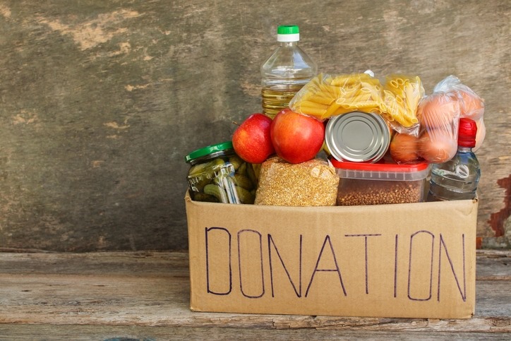 A cardboard box with 'Donations' written on it, filled with food.
