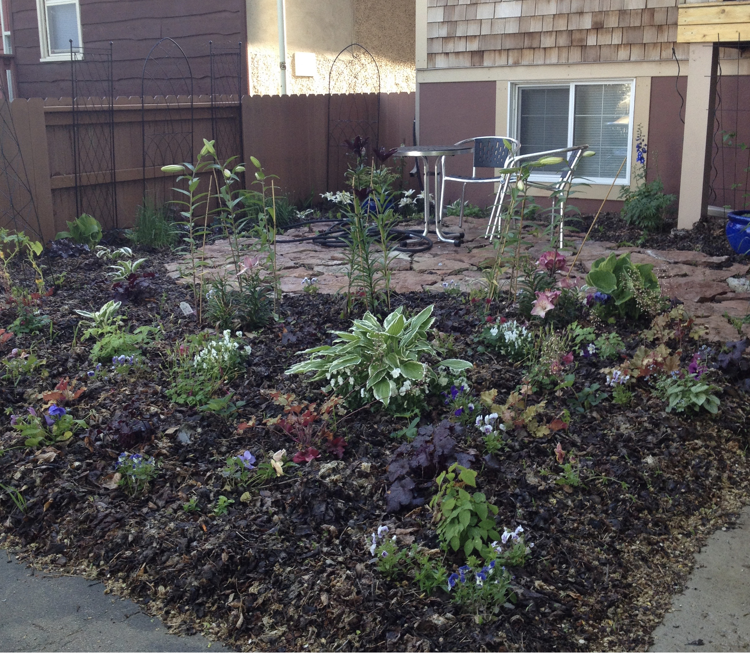 A mulched flower bed divides out a landscaped seating area.