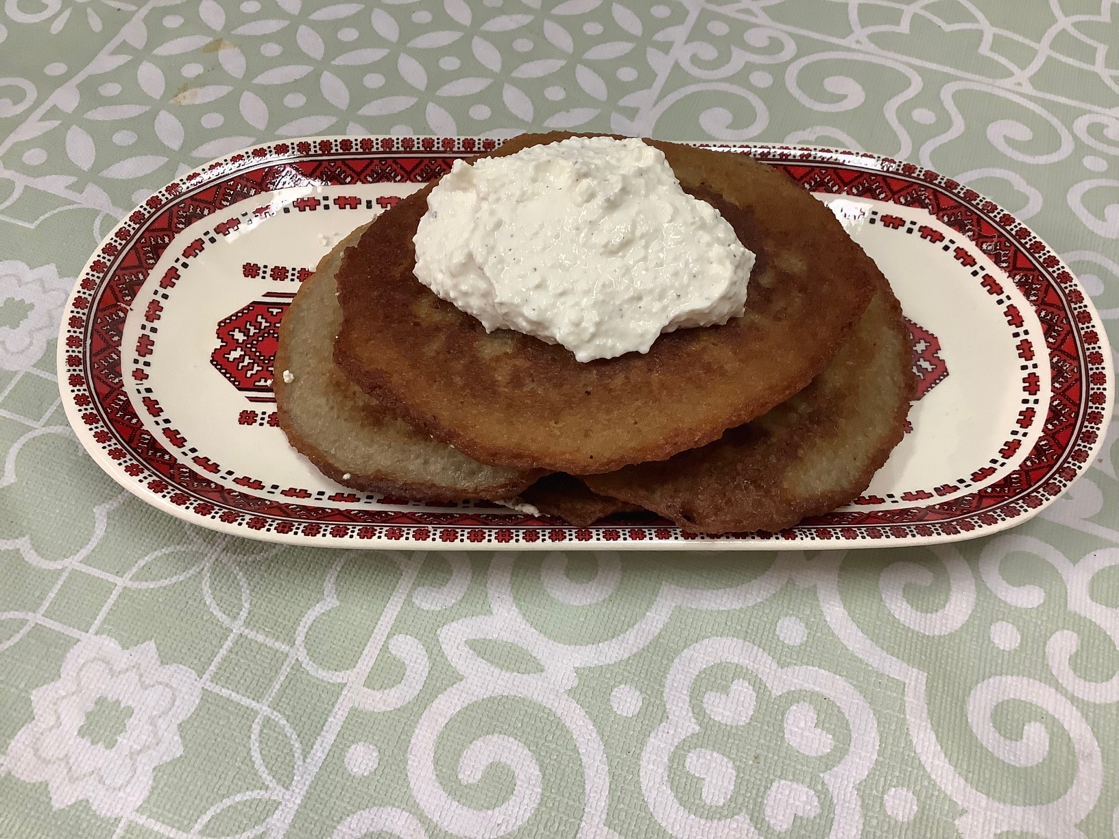 potato pancakes with topping on a decorated plate in the Ukrainian style